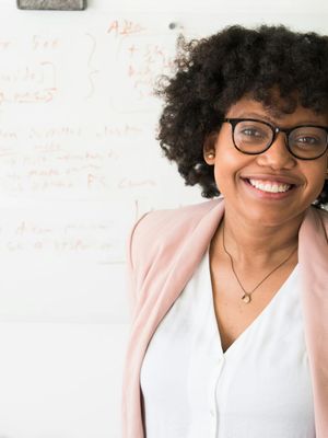 Portrait of a smiling, confident woman, the mentor of the practice, in a calm setting.